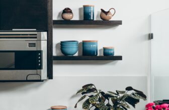 microwave beside containers on floating shelves