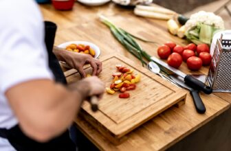 a person cutting up vegetables on a cutting board